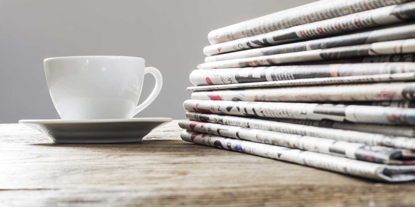 Zeitungen und Tasse auf einem Tisch